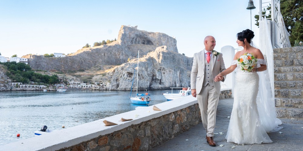 Bride and groom holding hands in Greece