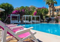 Pool area with sunbeds at Irini Hotel